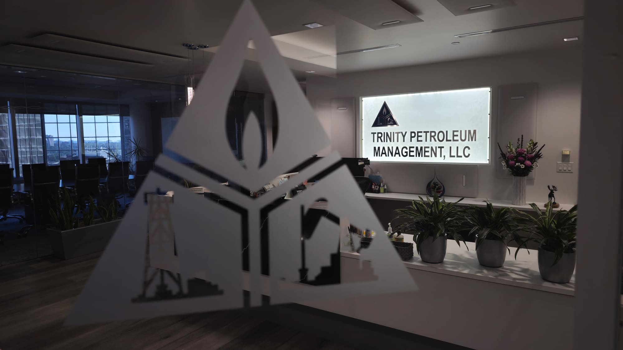 Trinity's triangle logo etched in frosted glass at the Denver office entrance
