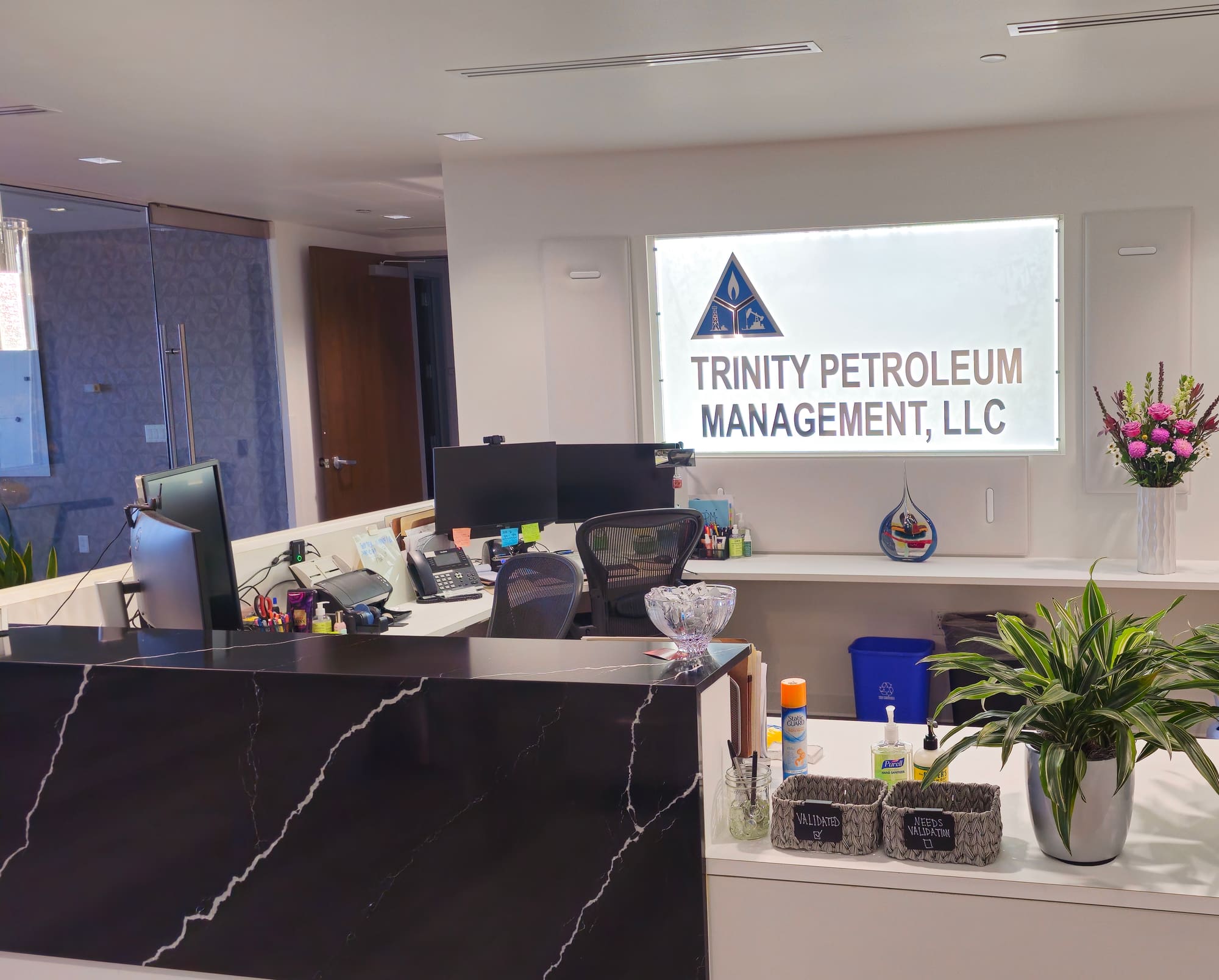 Trinity Petroleum Management reception with backlit logo sign